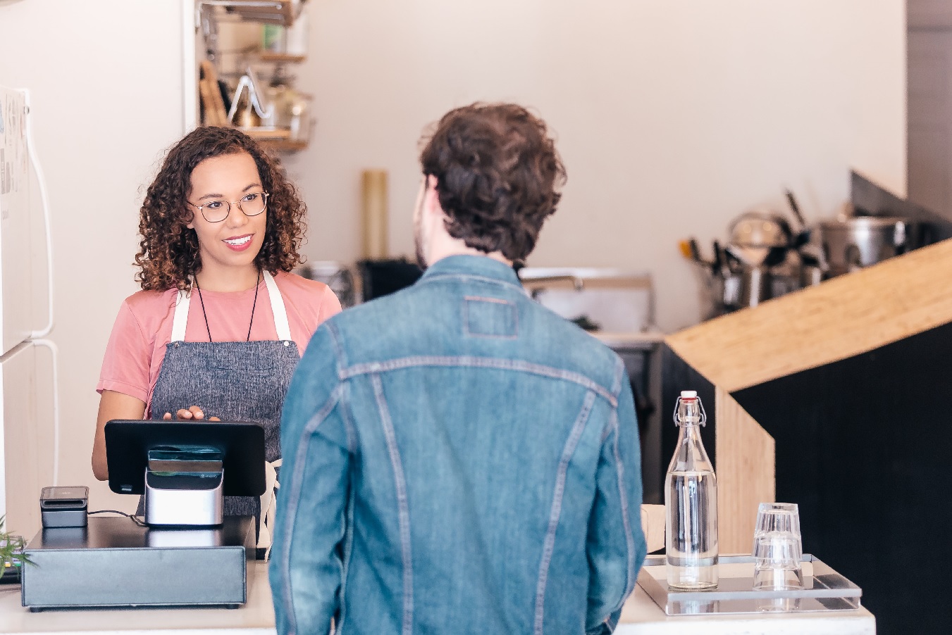 Barista serving coffee shop customer